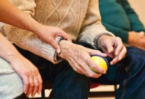 personne accompagnant un sénior au geste d'automassage DO-IN