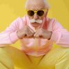 homme âgé, sur fond jaune, avec des lunettes de soleil